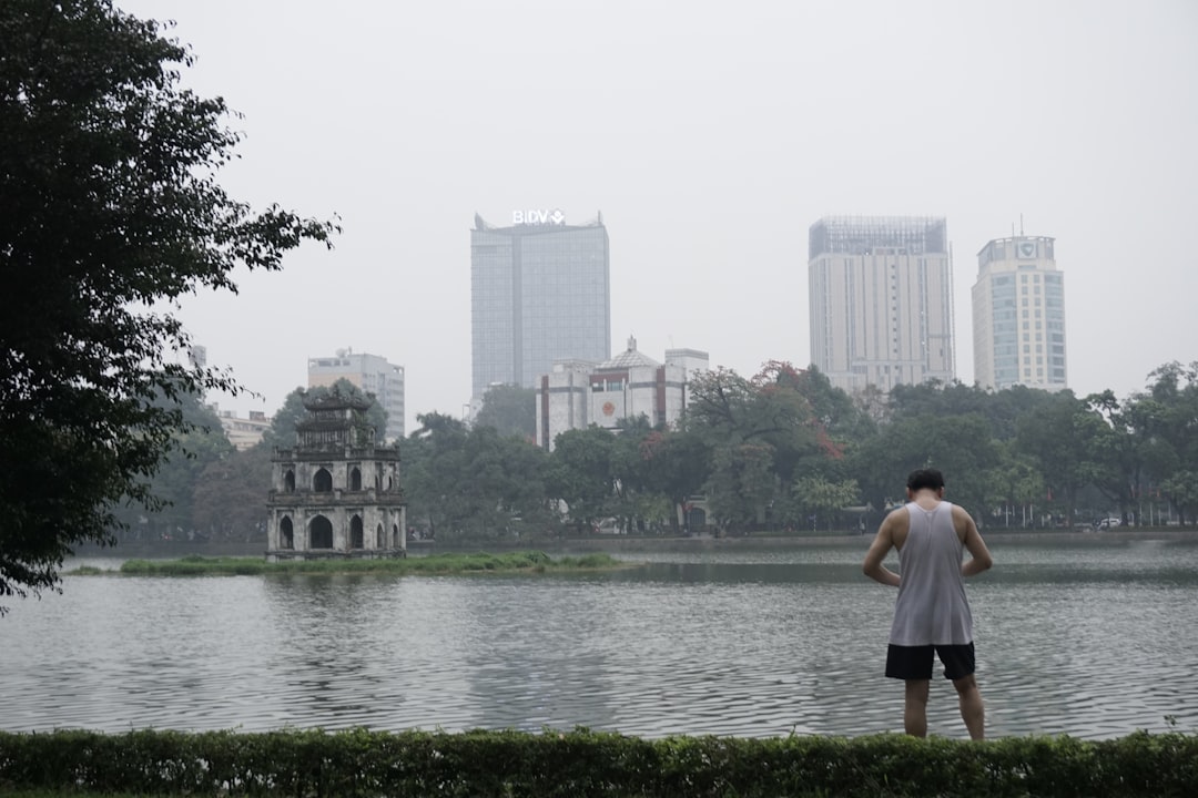 Hoan Kiem Lake in Hanoi surrounded by spring greenery and morning mist