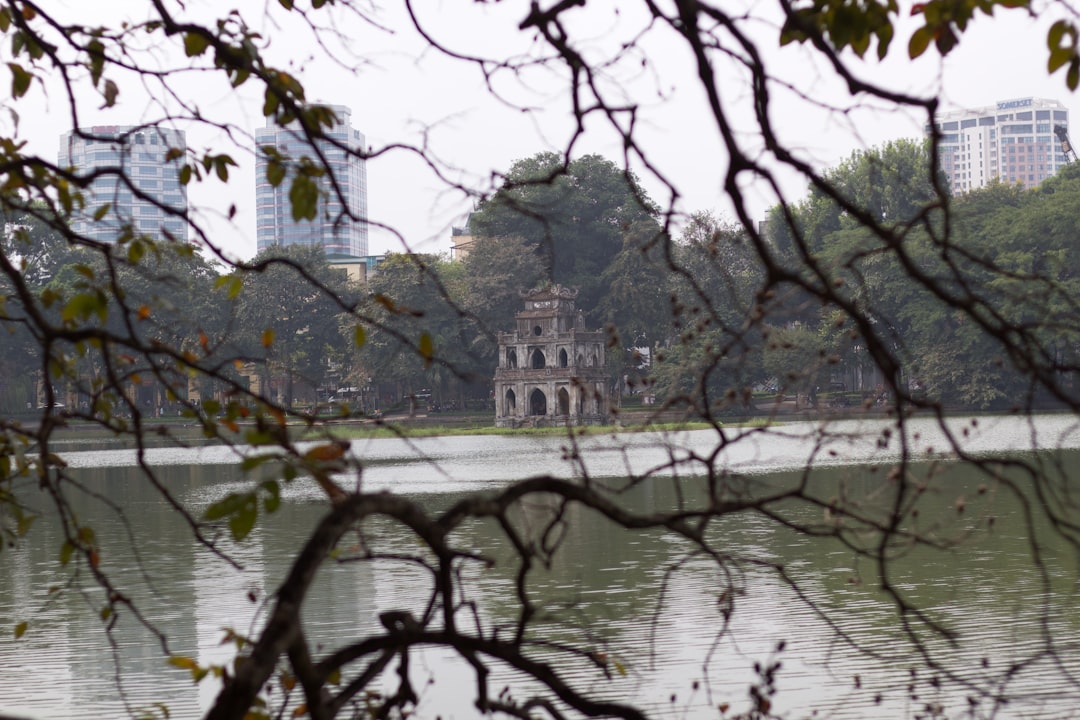 Ancient temple gate in Hanoi with spring flowers and incense smoke