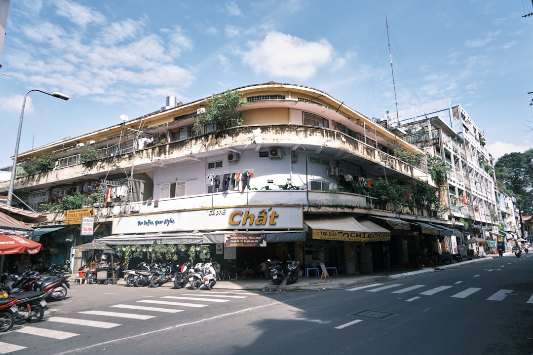 Busy street scene in Ho Chi Minh City with motorbikes and colonial buildings